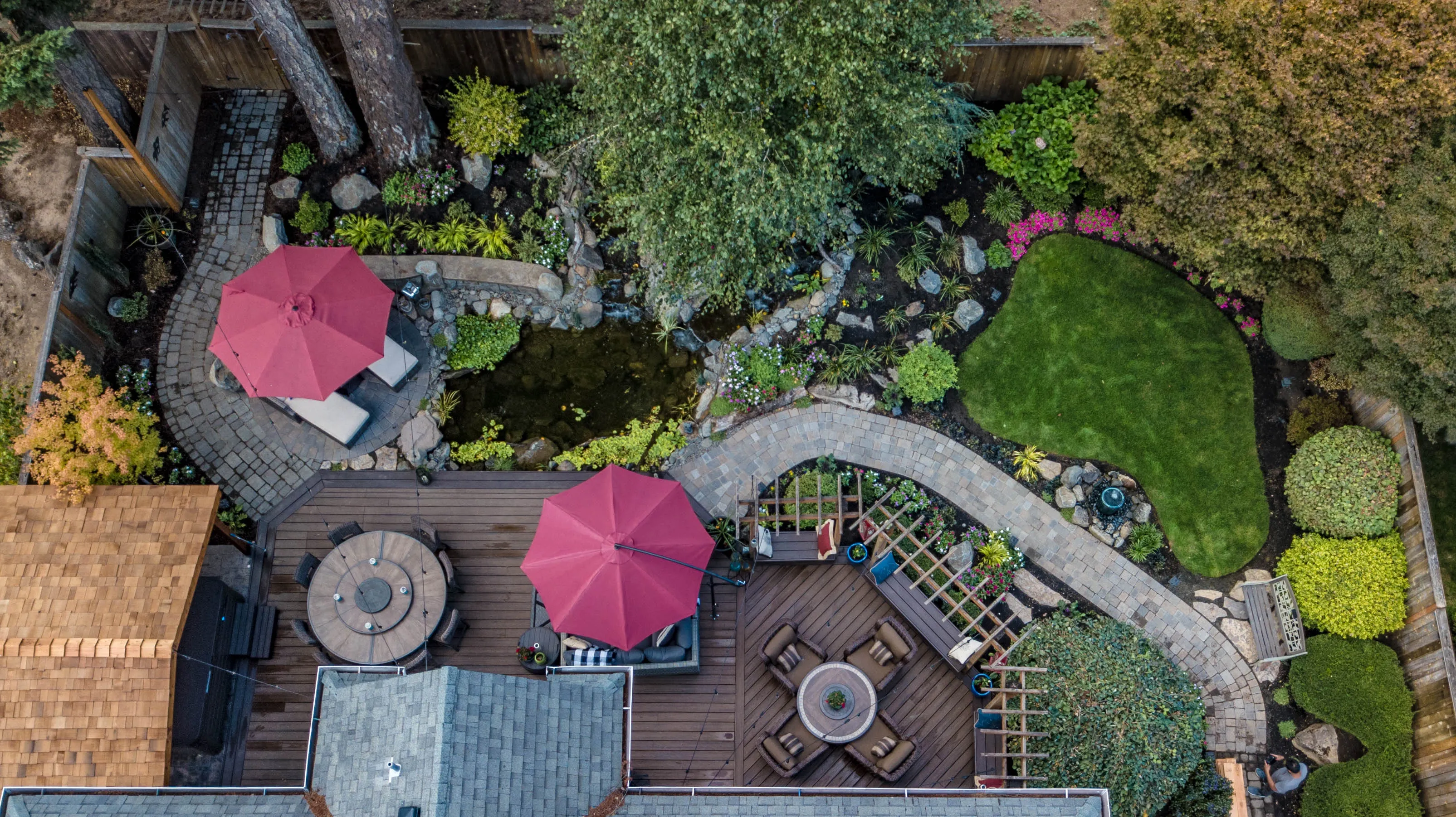 Aerial view of a complete backyard design/build: deck, paver paths, pond, and lawn